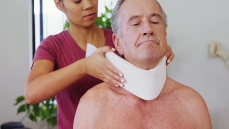 Physiotherapist-adjusting-cervical-collar-on-the-patients-neck-4k