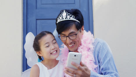 Padre-E-Hija-Disfrazados-De-Hadas-Tomándose-Un-Selfie-Con-Teléfono-Móvil-4k