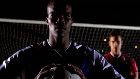 Portrait-of-confident-soccer-player-holding-ball-with-rival-athlete-4k