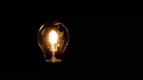 Illuminated-;light-bulb-against-black-background-4k