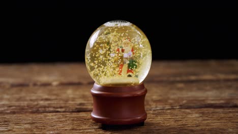Christmas-crystal-ball-on-wooden-table-4k