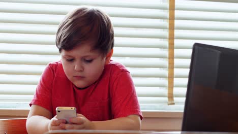 Boy-using-mobile-phone-at-home-4k