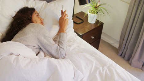 Frau-Liegt-Im-Bett-Und-Benutzt-Ihr-Mobiltelefon-Im-Schlafzimmer-4k-4k