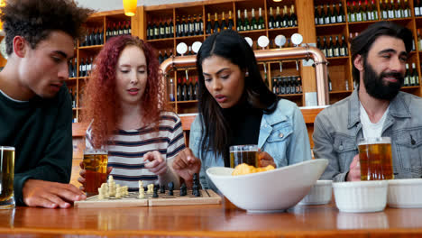 Freunde-Spielen-Schach,-Während-Sie-In-Der-Bar-4k-Ein-Glas-Bier-Trinken