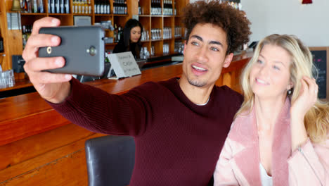 Couple-taking-selfie-with-mobile-phone-in-bar-4k