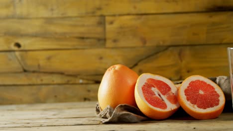 Grapefruit-with-juice-maker-on-wooden-table-4k
