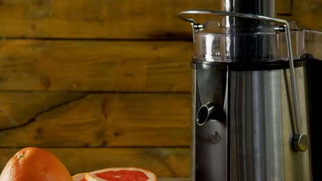 Grapefruit-and-juice-maker-on-a-wooden-table-4k