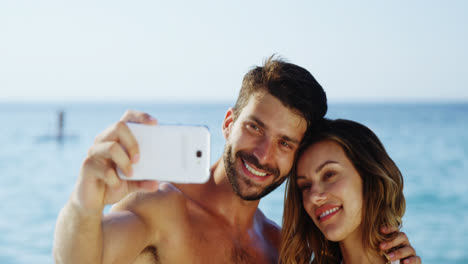 Couple-taking-selfie-with-mobile-phone-at-beach-4k
