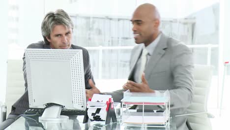 Two-upset-businessmen-working-at-a-computer