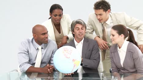 Multicultural-business-team-looking-at-a-terrestrial-globe-
