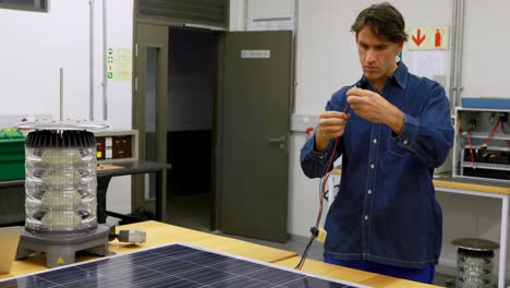 Male-worker-working-on-solar-panel-in-office-4k