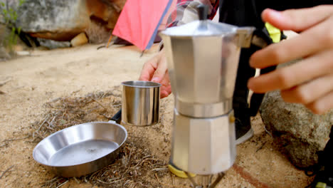 Man-pouring-tea-into-mug-from-tea-kettle-4k