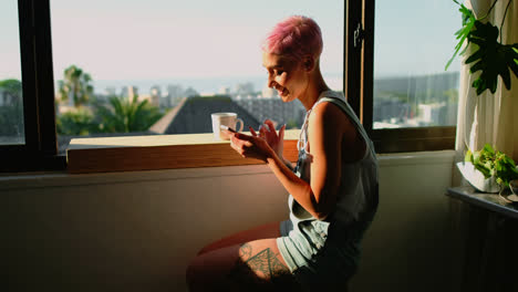 Woman-sitting-near-window-and-using-mobile-phone-4k