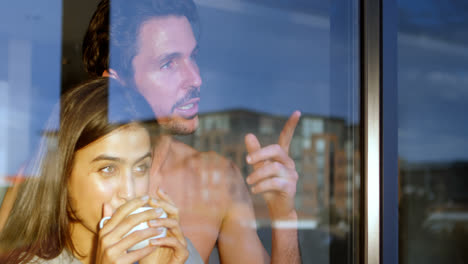 Couple-looking-through-window-while-having-coffee-4k