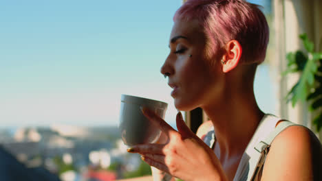 Woman-having-cup-of-coffee-and-looking-through-window-4k