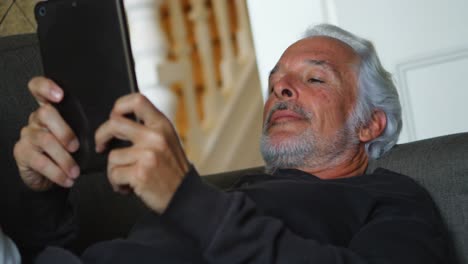 Senior-man-using-digital-tablet-on-sofa-4k