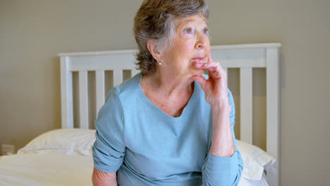 Senior-woman-sitting-on-bed-in-bedroom-4k
