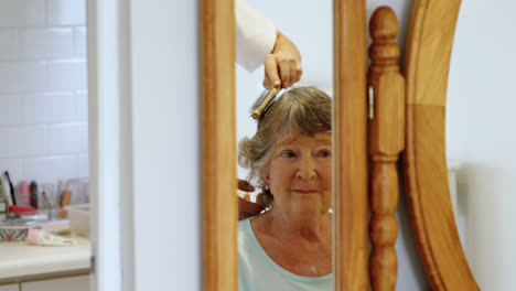 Combing-senior-woman-hair-front-of-mirror-4k
