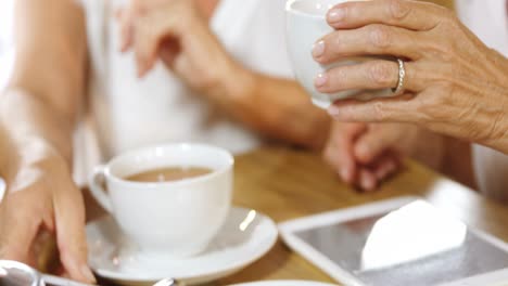 Senior-woman-having-coffee-while-chatting-with-friends-4k