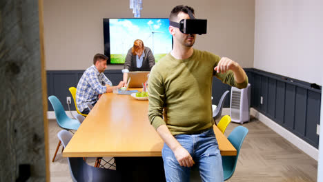 Führungskraft-Nutzt-Virtual-Reality-Headset,-Während-Kollegen-Im-4K-Hintergrund-Arbeiten