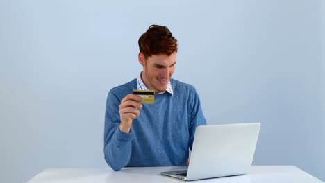 Man-with-credit-card-making-transaction-on-laptop-4k