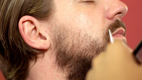 Man-getting-his-beard-trimmed-with-scissors-4k