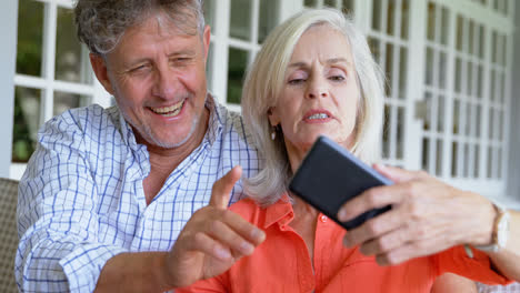Älteres-Paar-Diskutiert-über-Mobiltelefon-Auf-Der-Veranda-4K
