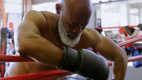 Senior-boxer-leaning-on-the-boxing-ring-4k