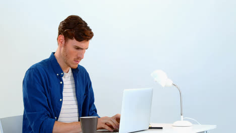 Man-using-laptop-on-desk-against-white-background-4k