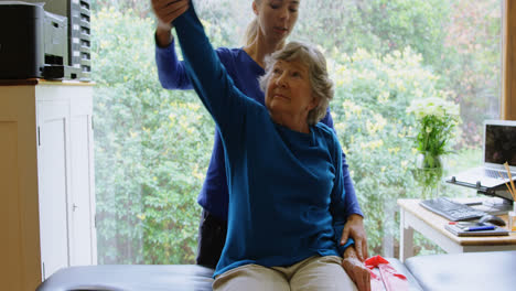 Physiotherapist-stretching-senior-woman-shoulder-4k