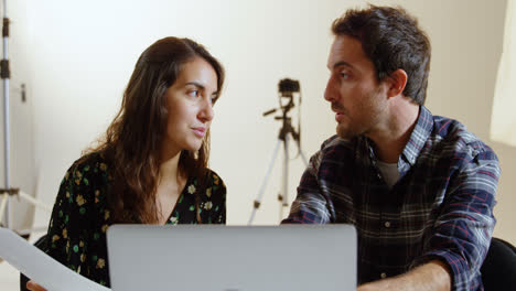 Photographers-discussing-over-laptop-at-desk-4k
