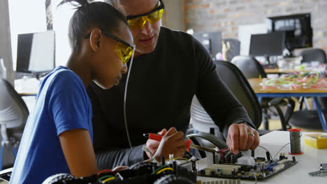 Father-teaching-her-daughter-about-soldering-iron-4k
