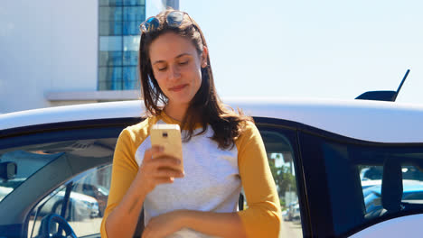 Woman-using-mobile-phone-near-her-car-4k
