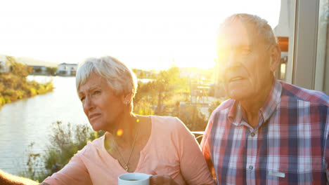 Senior-couple-with-coffee-cup-standing-in-balcony-4k