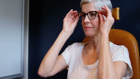 Senior-woman-adjusting-eyeglasses-in-clinic-4k