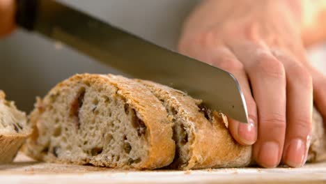 Woman-cutting-loaf-of-bread-4k