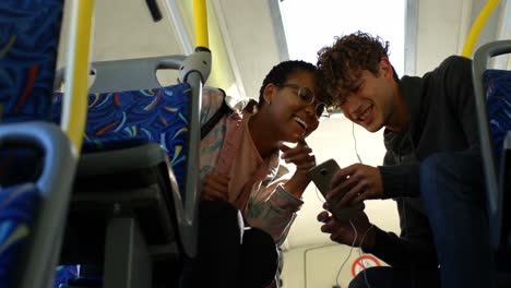 Couple-using-mobile-phone-while-travelling-in-bus-4k