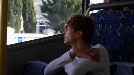 Male-commuter-looking-through-window-while-travelling-in-bus-4k