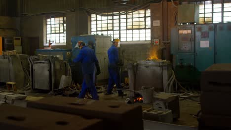 Gruppe-Von-Arbeitern,-Die-Geschmolzenes-Metall-In-Der-Werkstatt-4k-Erhitzen