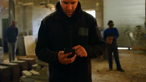 Male-worker-using-mobile-phone-in-workshop-4k