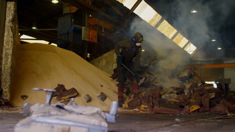 Male-worker-breaking-hot-mold-in-foundry-workshop-4k