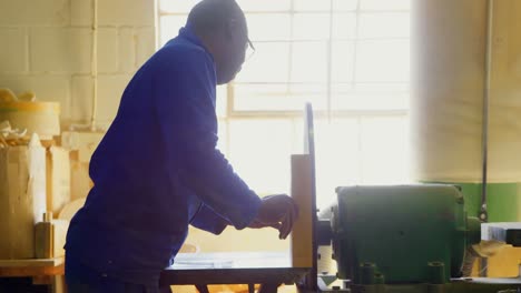 Male-worker-cutting-wooden-block-in-workshop-4k