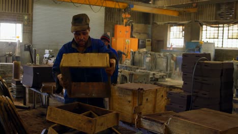 Male-worker-arranging-wooden-mold-block-n-workshop-4k