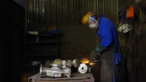 Male-worker-using-grinder-machine-in-workshop-4k
