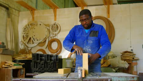Male-working-on-wooden-block-in-workshop-4k