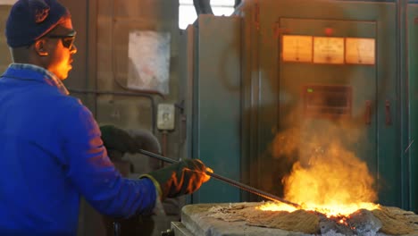 Worker-melting-metal-in-furnace-at-workshop-4k