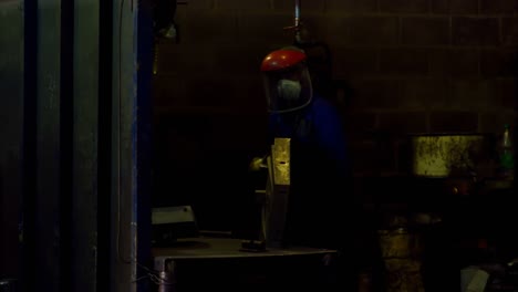 Worker-using-hand-grinder-machine-in-foundry-workshop-4k