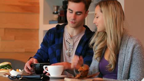 Couple-interacting-with-each-other-while-having-coffee-in-cafe-4k