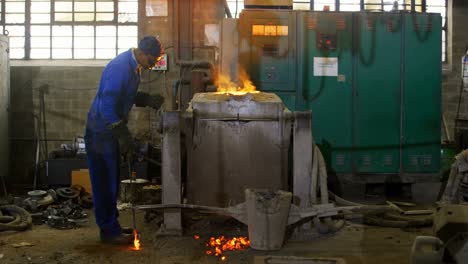 Worker-melting-metal-in-furnace-at-workshop-4k