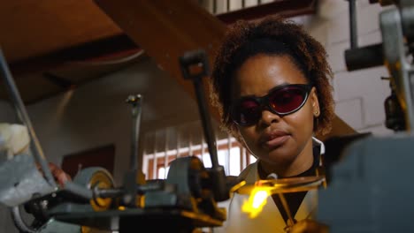 Attentive-black-female-worker-blowing-glass-in-glass-factory-4k